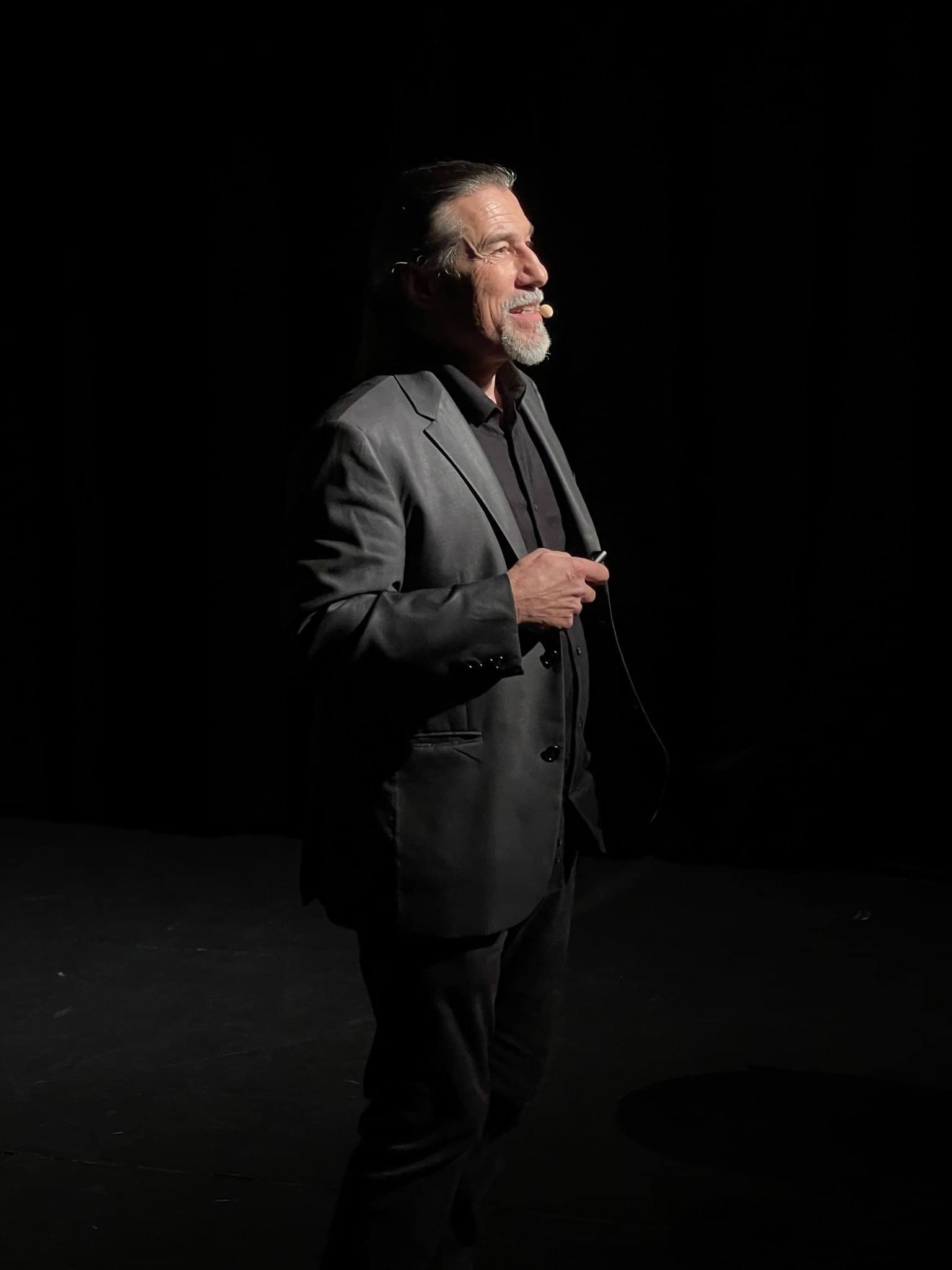 Serge Avril en conférence, de profil sur scène